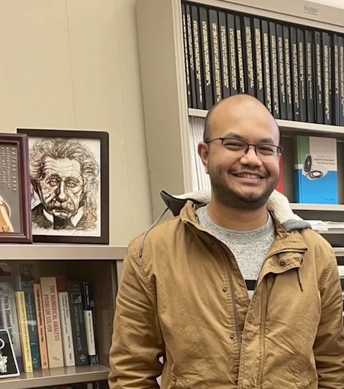 Aniruddha Bora in front of bookshelves